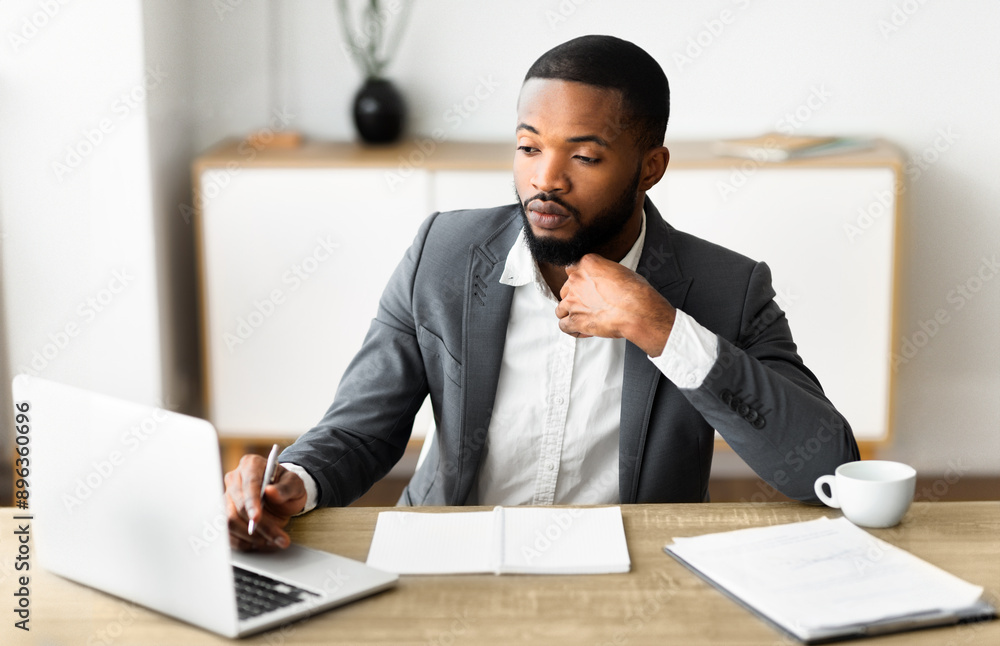 Portrait of confident black businessman in formal suit working in modern office interior, selective focus on man Portrait of confident black businessman in formal suit working in modern office interior, selective focus on man