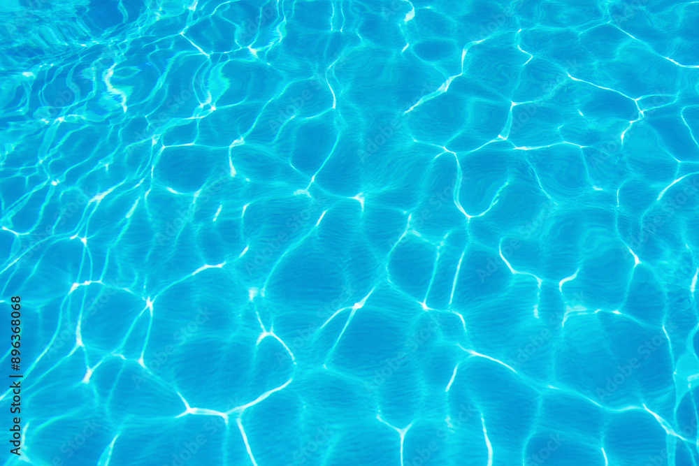 Obraz premium Ripples on the surface of the water in a blue swimming pool