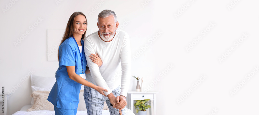 Obraz premium Female caregiver helping senior man with walking stick in bedroom