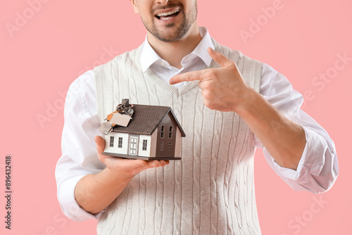 Male real estate agent poin...