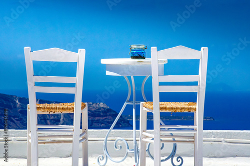 Two chairs and a small table with a wonderful view in Santorini, Greece photo