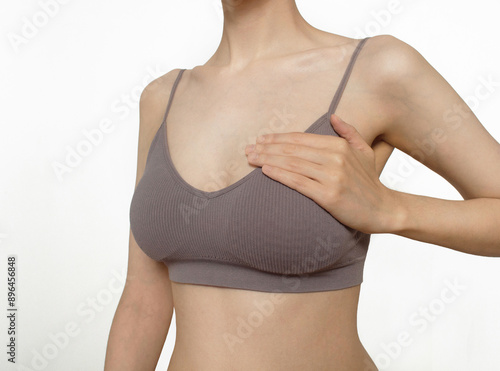 Fotografie Closeup cropped portrait young woman with breast/heart pain or  heartache  touching chest woman examining breast mastopathy or cancer  White background Healthcare concept