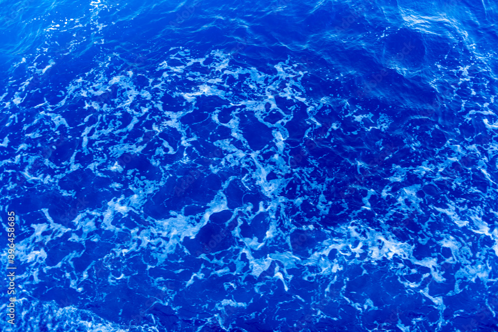 Obraz premium Texture of blue water under sun beams.