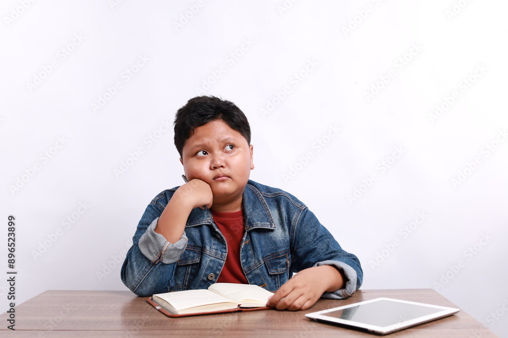 Asian schoolboy do not understand the lesson or have no idea how to do homework at home with New normal for learning online , Social distancing concept Asian schoolboy do not understand the lesson or have no idea how to do homework at home with New normal for learning online , Social distancing concept