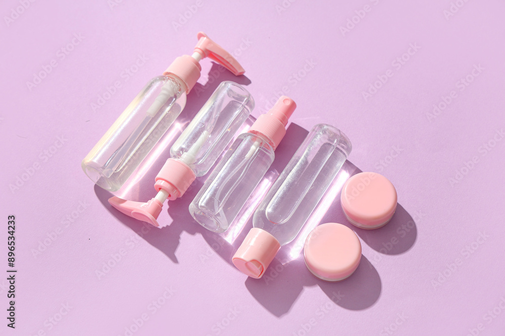 Set of different travel cosmetic products on lilac background Set of different travel cosmetic products on lilac background