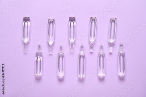 Glass ampules on purple background