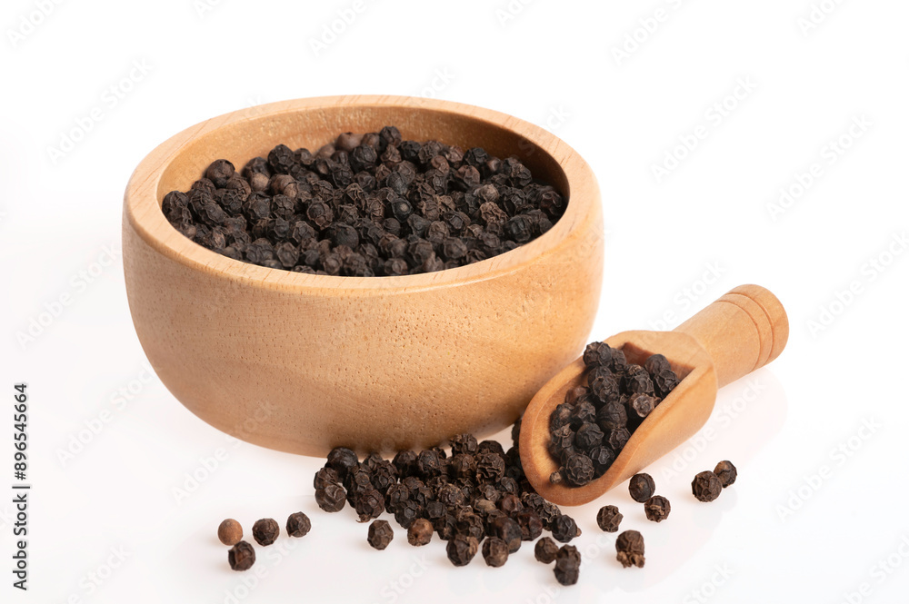 Black peppercorn seeds in wooden bowl and scoop isolated on white background. Black peppercorn seeds in wooden bowl and scoop isolated on white background.