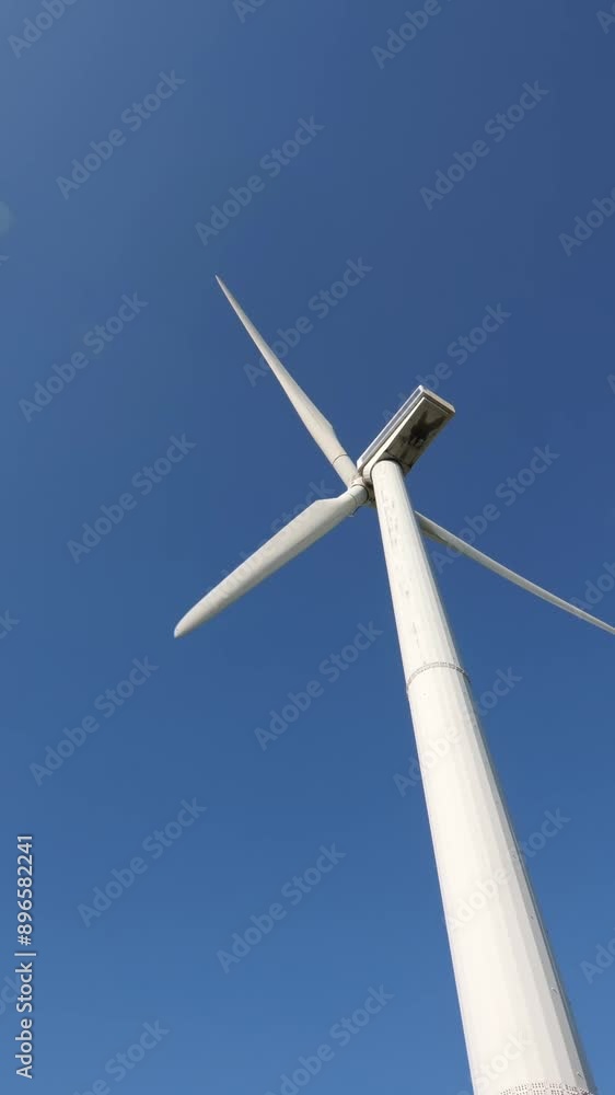 vertical video wind generator works against blue sky. blades of a wind generator vertical video wind generator works against blue sky. blades of a wind generator