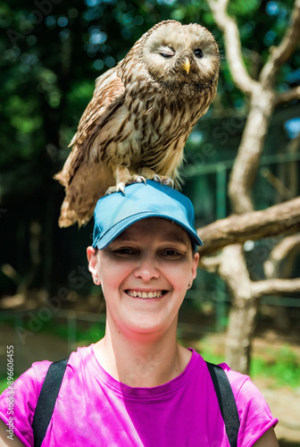 фотографія Portrait of laughing 36 years old Russian woman with Ural owl (Strix uralensis)