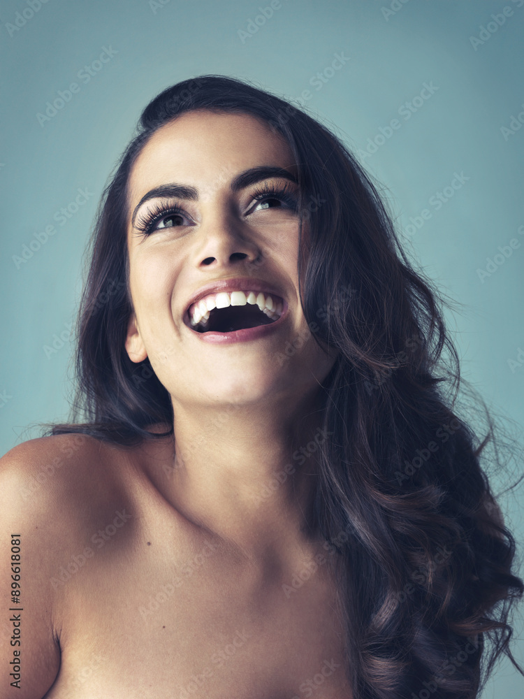 Laugh, thinking or woman in studio for hair care, smooth or growth with collagen treatment with results. Female model, beauty or cosmetics for soft texture, healthy volume or shine by blue background Laugh, thinking or woman in studio for hair care, smooth or growth with collagen treatment with results. Female model, beauty or cosmetics for soft texture, healthy volume or shine by blue background