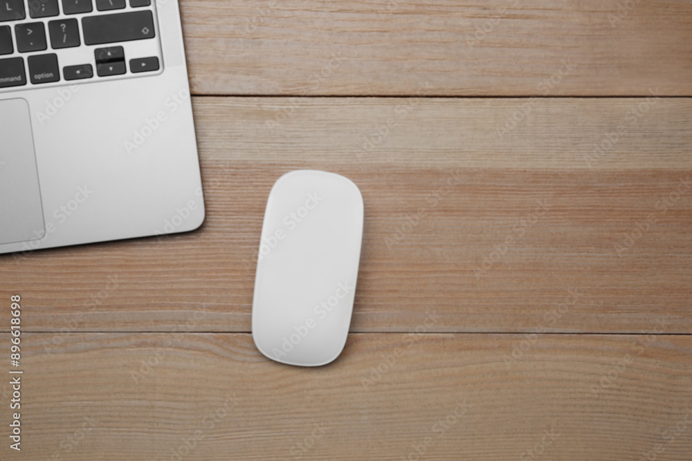 Wireless mouse and laptop on wooden table, top view. Space for text Wireless mouse and laptop on wooden table, top view. Space for text