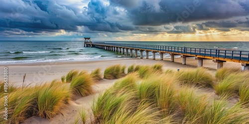 Fototapeta Naklejka Na Ścianę i Meble -  Pier at the baltic sea in Zinnowitz on an overcast day with dune grass and beach in the foreground, pier, baltic sea