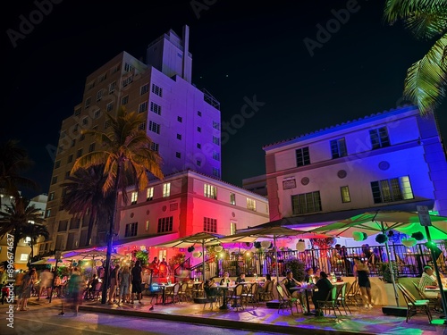 Fotografie Miami Beach, Florida - July 8, 2024: Art Deco buildings lit up at night on Ocean Drive in South Beach