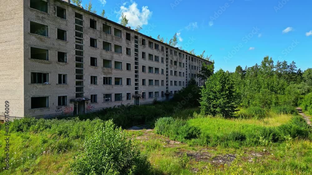 An abandoned multi-story building, surrounded and overgrown by lush vegetation, evoking a post-apocalyptic scene An abandoned multi-story building, surrounded and overgrown by lush vegetation, evoking a post-apocalyptic scene