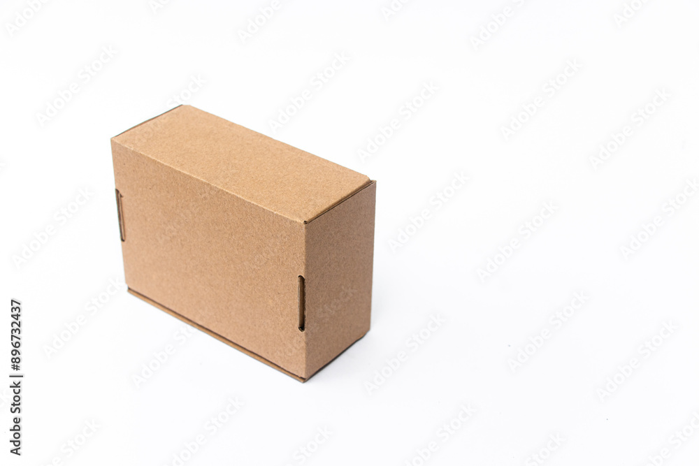 A small, plain cardboard box with a simple design, resting on a clean white surface. Perfect for shipping, storage, or packaging small items securely and efficiently. A small, plain cardboard box with a simple design, resting on a clean white surface. Perfect for shipping, storage, or packaging small items securely and efficiently.