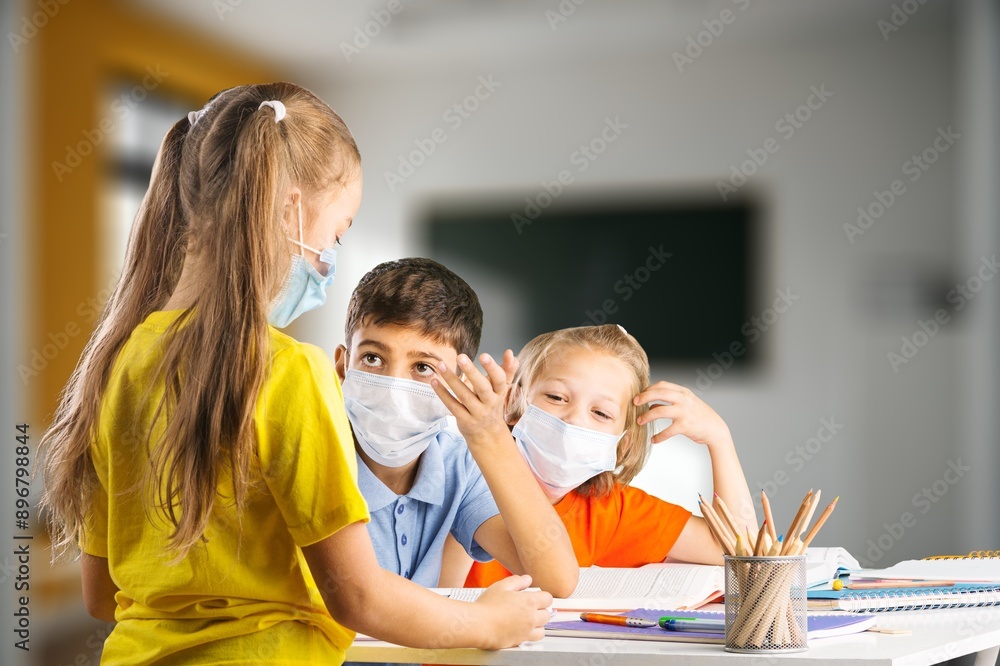 Smiling junior happy school student sittistng in classroom Smiling junior happy school student sittistng in classroom
