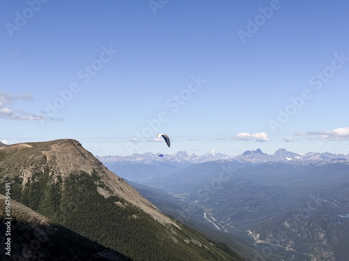 A paraglider flies over the mountains of the Canadian Rockies. Jasper, Canada.  photo