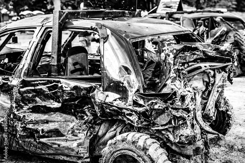 Dented and damaged rear end of a modified car used for a demolition derby. photo