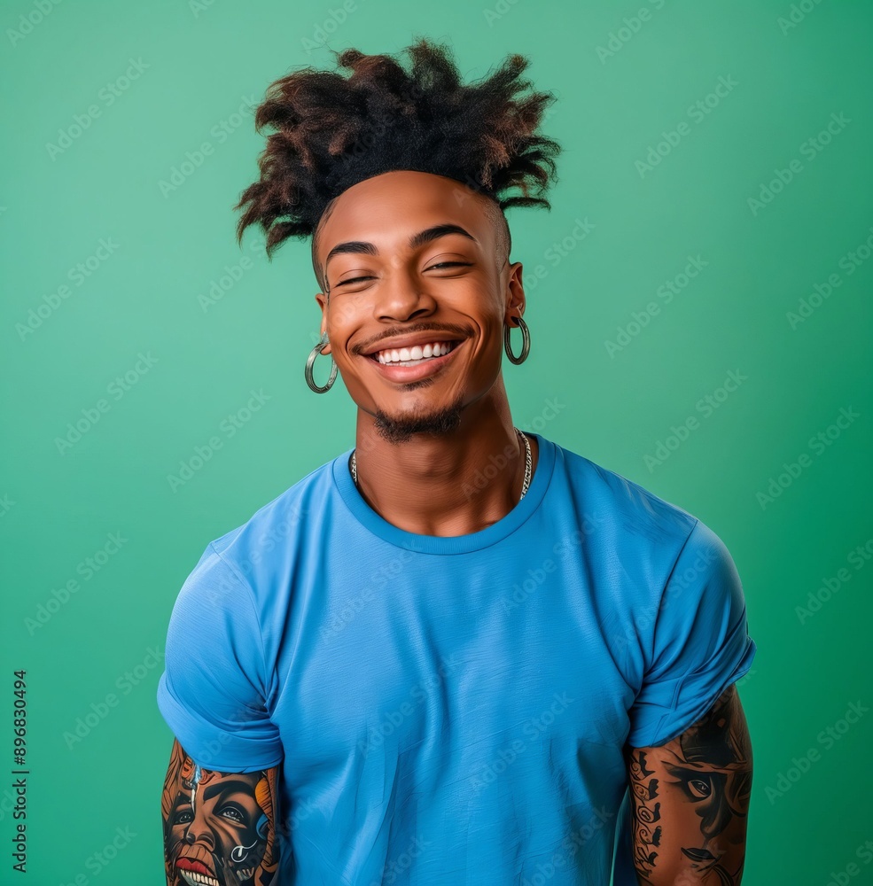 A young man with tattoos and dreadlocks smiling. A young man with tattoos and dreadlocks smiling.
