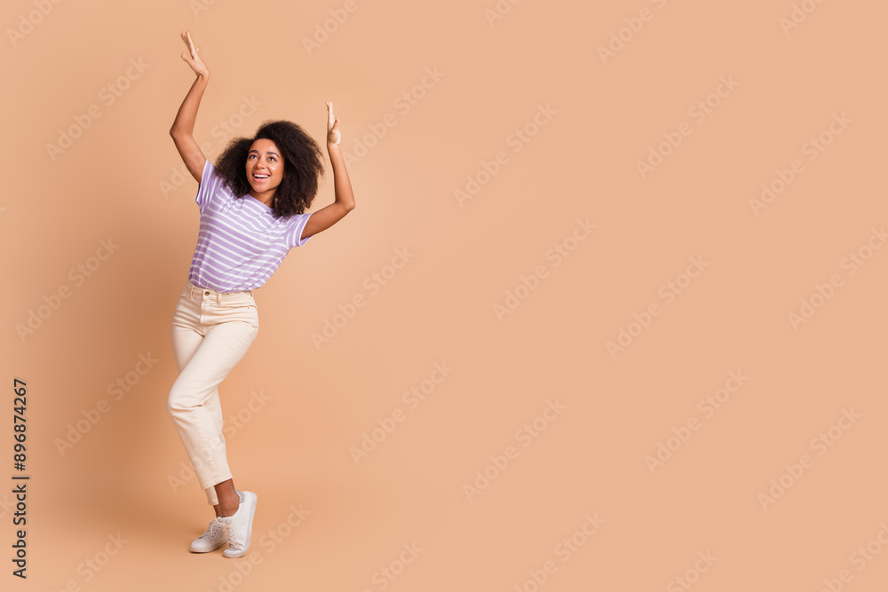 Full size photo of nice young woman dance empty space wear t-shirt isolated on beige color background Full size photo of nice young woman dance empty space wear t-shirt isolated on beige color background