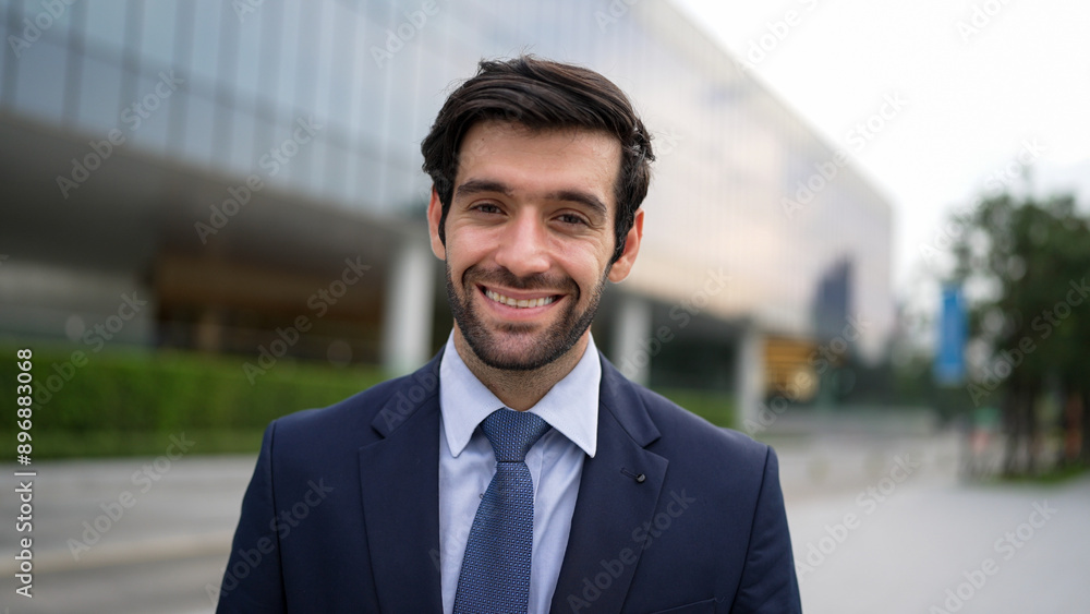 Portrait of smiling business man looking at camera while standing at building. Closeup of successful man smiling at camera while wearing business suit. Happy manager look at camera. Exultant. Portrait of smiling business man looking at camera while standing at building. Closeup of successful man smiling at camera while wearing business suit. Happy manager look at camera. Exultant.