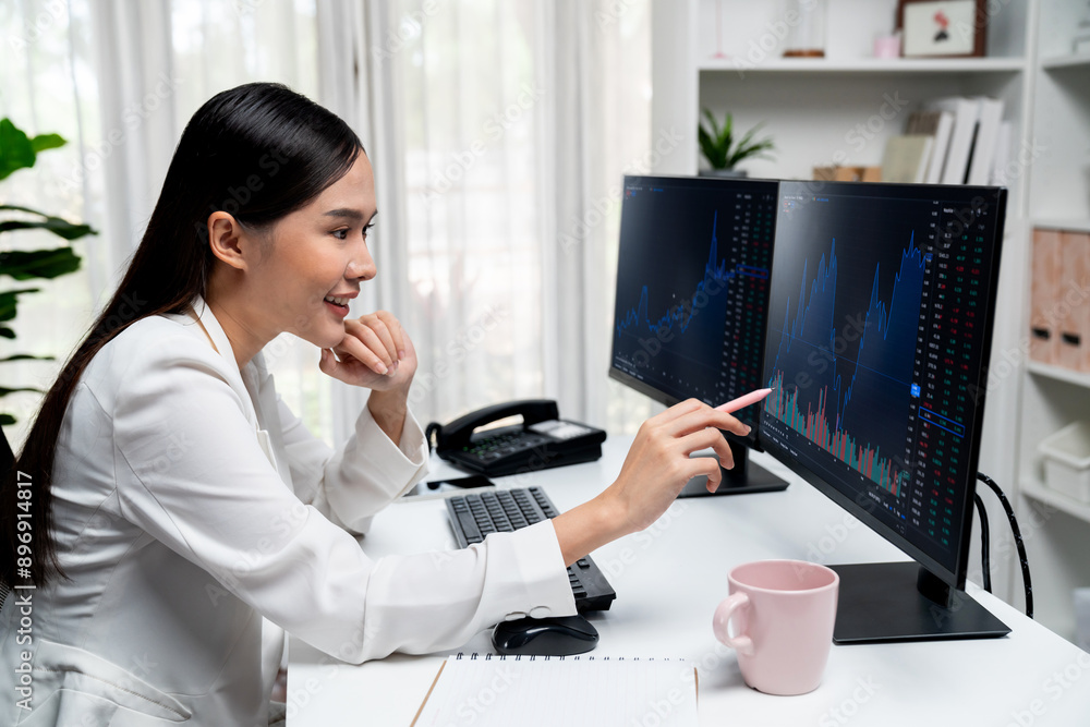 Young beautiful Asian businesswoman looking on pc to analyze profitable of exchange stock market graph at modern office. Concept of investing high profit in wealth security in finance. Stratagem. Young beautiful Asian businesswoman looking on pc to analyze profitable of exchange stock market graph at modern office. Concept of investing high profit in wealth security in finance. Stratagem.