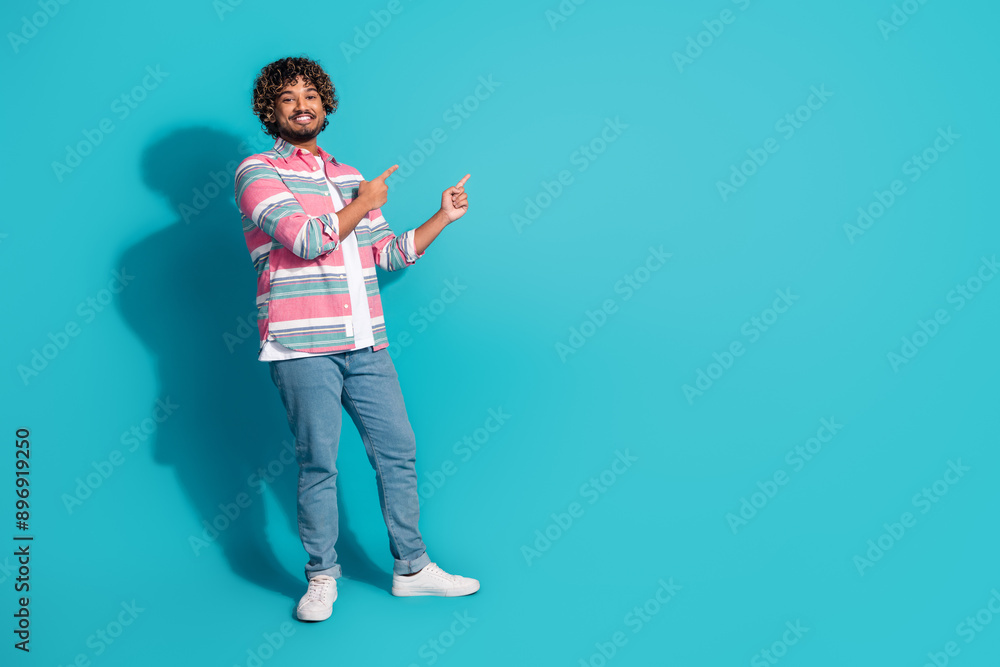 Photo of cheerful handsome man wear stylish striped clothes presents empty space isolated on cyan color background Photo of cheerful handsome man wear stylish striped clothes presents empty space isolated on cyan color background