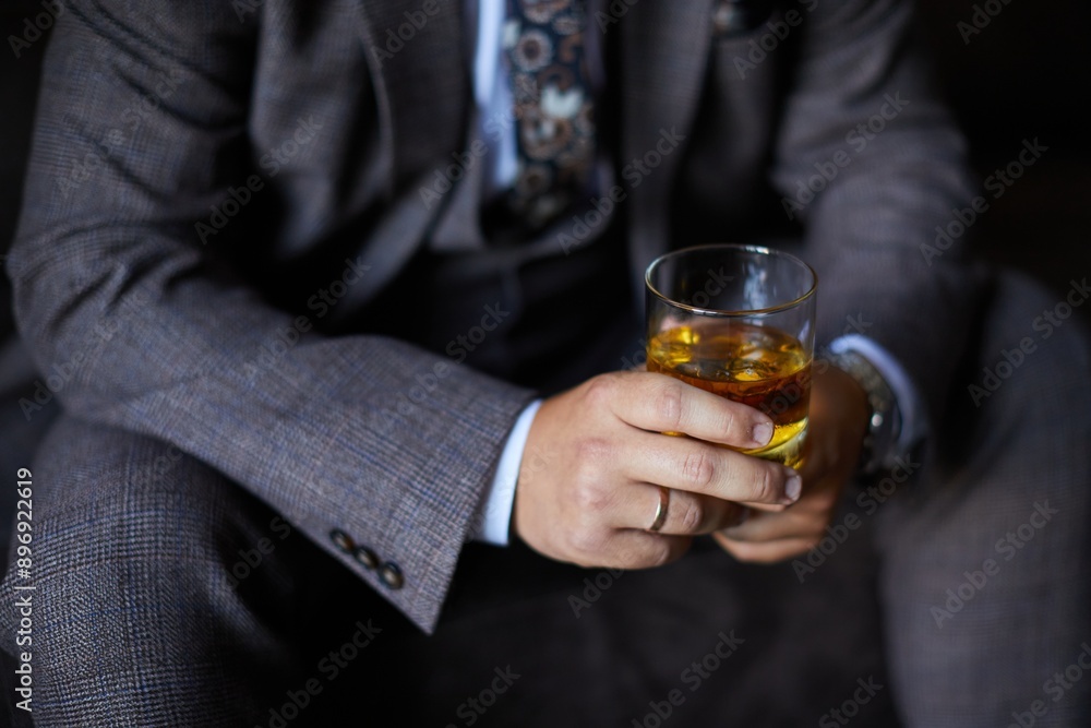 A glass of whiskey in the hands of a man who is sitting A glass of whiskey in the hands of a man who is sitting