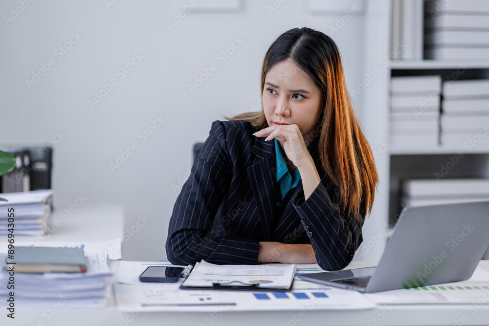 Portrait of tired business asian woman sitting at a work. documents tax laptop computer in office. Sad, unhappy, Worried, Depression, or overworked, failure employee life stress concept Portrait of tired business asian woman sitting at a work. documents tax laptop computer in office. Sad, unhappy, Worried, Depression, or overworked, failure employee life stress concept