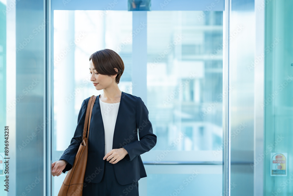 エレベーターのボタンを押す女性