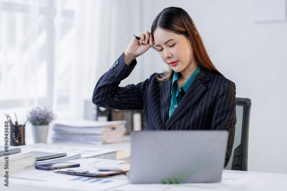 Portrait of tired business asian woman sitting at a work. documents tax laptop computer in office. Sad, unhappy, Worried, Depression, or overworked, failure employee life stress concept Portrait of tired business asian woman sitting at a work. documents tax laptop computer in office. Sad, unhappy, Worried, Depression, or overworked, failure employee life stress concept