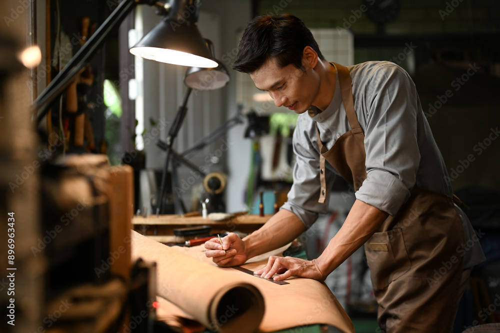 Handsome asian craftsman working meticulously in a workshop. Small business and handmade concept Handsome asian craftsman working meticulously in a workshop. Small business and handmade concept