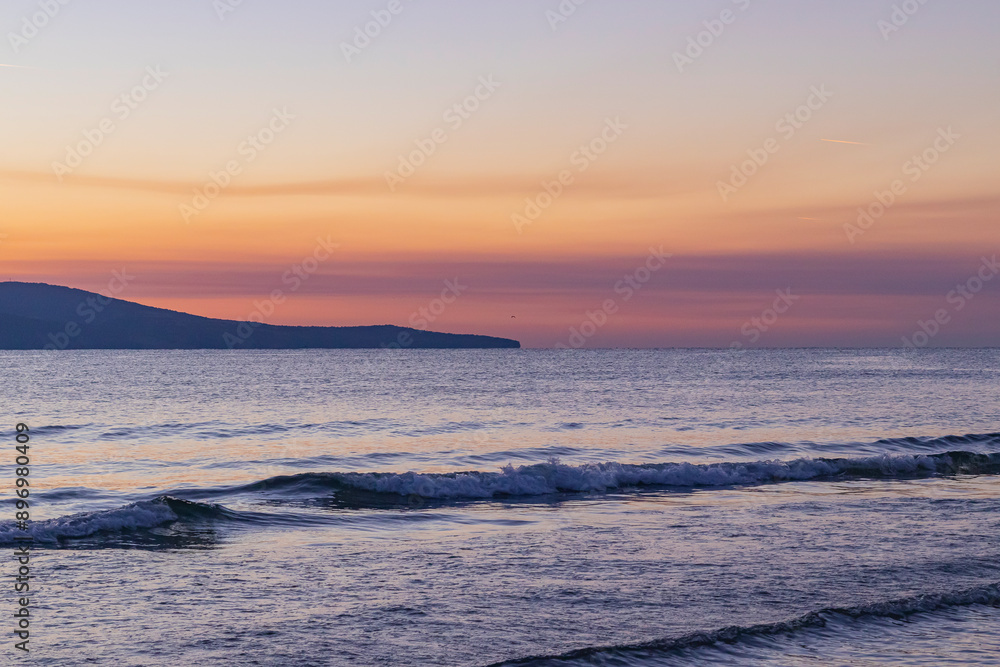 seashore at dawn, waves rolling onto the shore and a colorful sky seashore at dawn, waves rolling onto the shore and a colorful sky