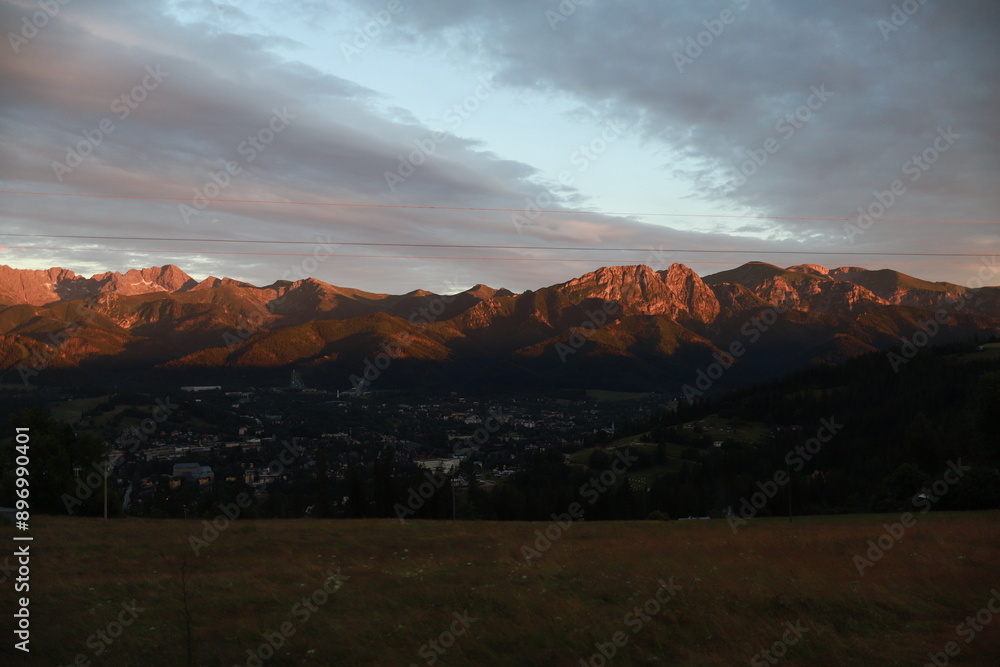 The mountain range is illuminated by the light of the sunset. Red warm lighting in the mountains. The Rocky Mountains are illuminated by the sunset. The mountain range is illuminated by the light of the sunset. Red warm lighting in the mountains. The Rocky Mountains are illuminated by the sunset.