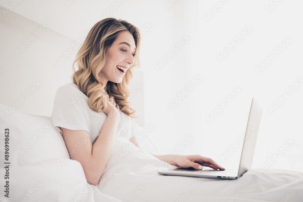 Photo of excited girl worker lying bed using watch netbook in day light bedroom Photo of excited girl worker lying bed using watch netbook in day light bedroom