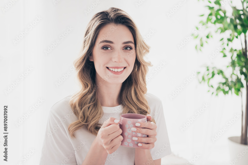 Photo of positive smiling hold cup coffee enjoy in white day light room Photo of positive smiling hold cup coffee enjoy in white day light room