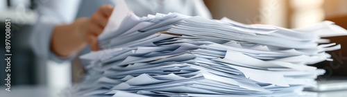 Close up of a stack of white paper documents on a desk, a business woman working with a pile in the office