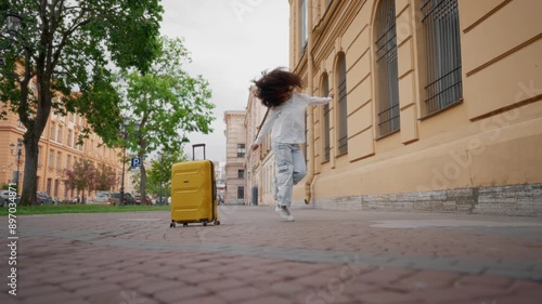 Happy jumping woman tourist, Arab girl traveling and rejoicing by journey. Beautiful multiethnic lady has fun and good mood, black student girl waving her long hair, crazy townswoman or passer-by photo