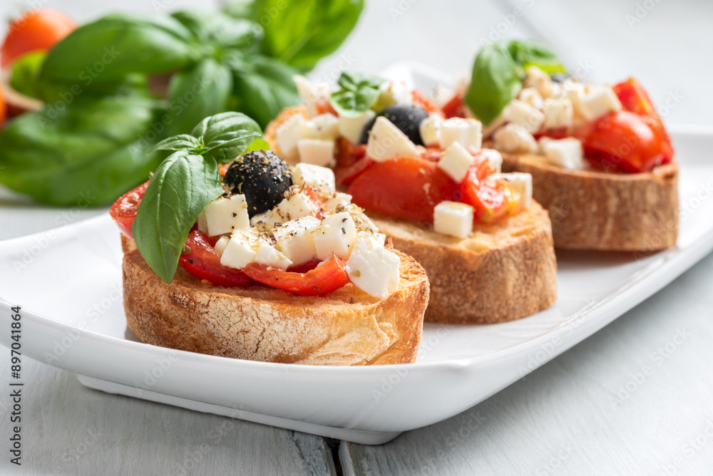 Bruschette con pomodoro fresco, mozzarella, olive, basilico e olio extravergine di oliva, spuntino italiano, dieta mediterranea Bruschette con pomodoro fresco, mozzarella, olive, basilico e olio extravergine di oliva, spuntino italiano, dieta mediterranea