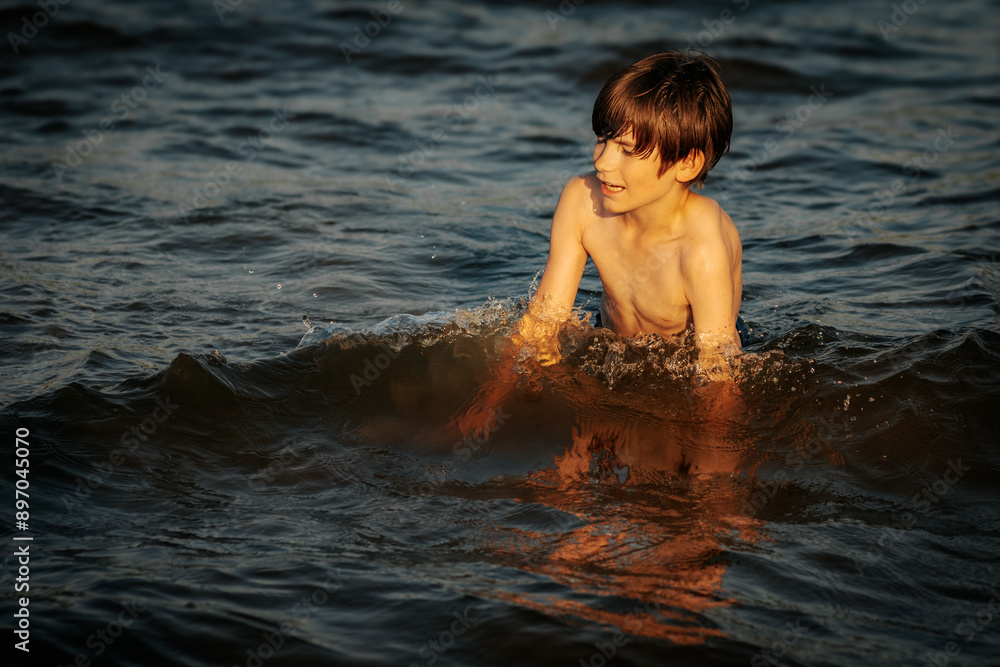 A boy swimming in the ocean, smiling and flashing a peace sign with his fingers. The image captures a joyful and carefree moment during a summer day at the beach A boy swimming in the ocean, smiling and flashing a peace sign with his fingers. The image captures a joyful and carefree moment during a summer day at the beach