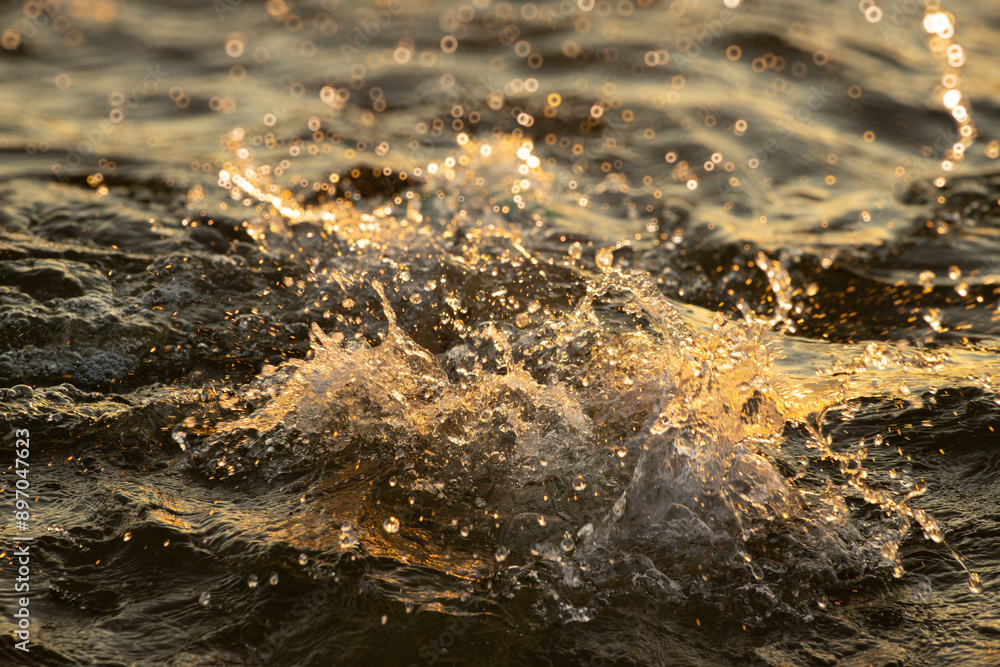 Close-up of golden waves rolling in at sunset, capturing the dynamic and shimmering beauty of the ocean. The image highlights the play of light on the water, creating a warm and vibrant scene. Close-up of golden waves rolling in at sunset, capturing the dynamic and shimmering beauty of the ocean. The image highlights the play of light on the water, creating a warm and vibrant scene.