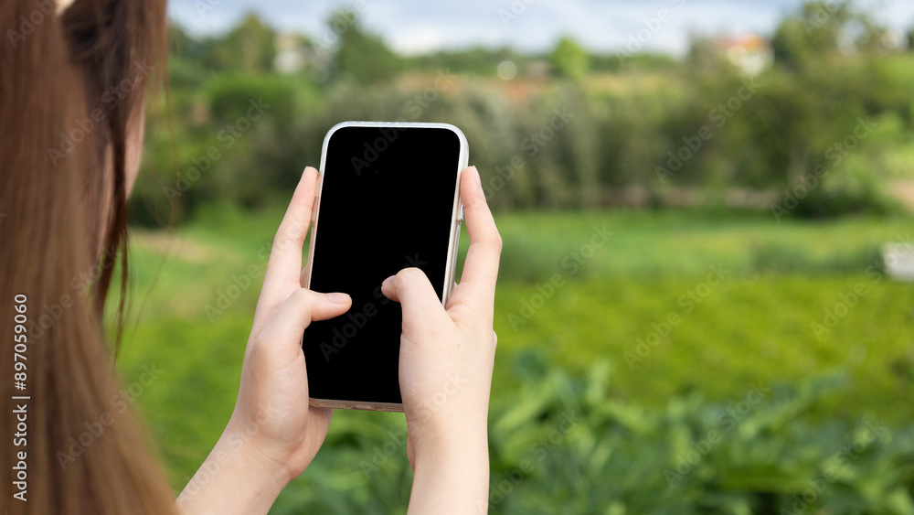 Close up of a business woman's hand holding and using a smartphone with a blank black screen to display your graphics. Close up of a business woman's hand holding and using a smartphone with a blank black screen to display your graphics.