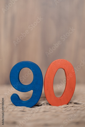 Close-up wooden figure number ninety on a beige blurred background photo