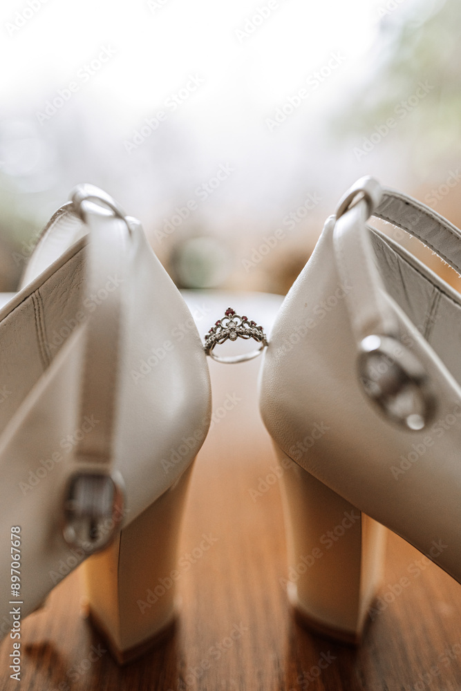 Two white shoes with a ring on the left one Two white shoes with a ring on the left one