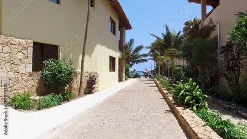 Footage of the beautiful street leading on the beach in Sal Cape Verde Cabo Verde in the summer time showing the romantic relaxing beach front and houses close by on a sunny day in the summer time