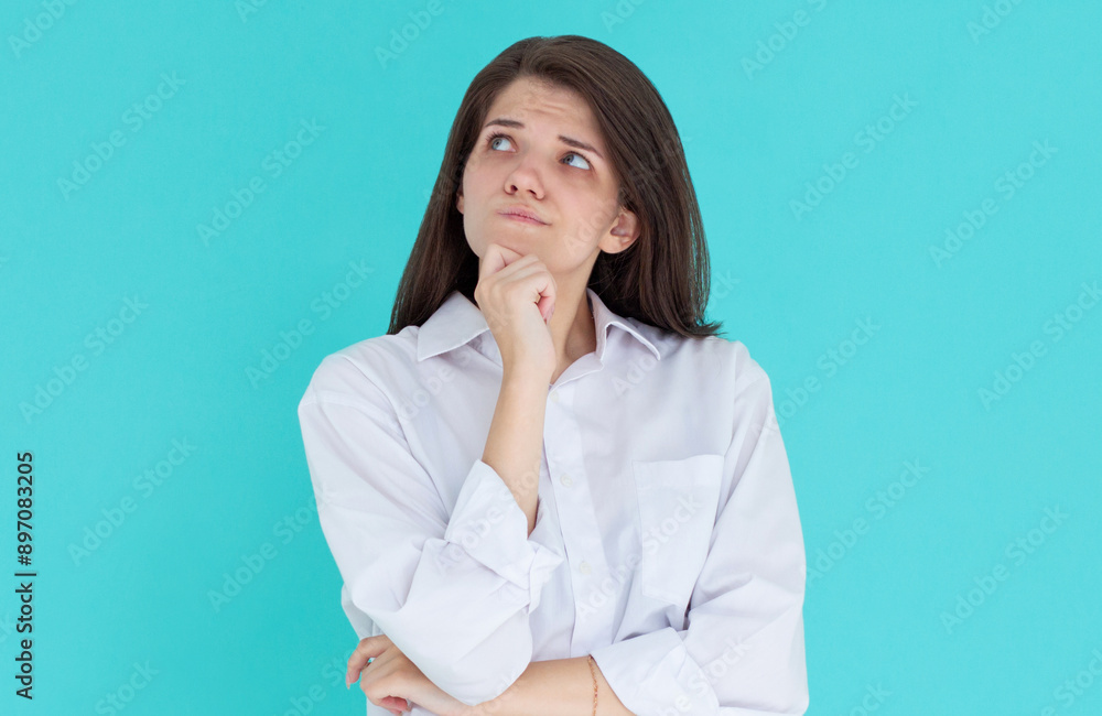 Closeup photo of amazing lady looking up empty space deep thinking creative person arm on chin wear casual white shirt isolated blue color background Closeup photo of amazing lady looking up empty space deep thinking creative person arm on chin wear casual white shirt isolated blue color background