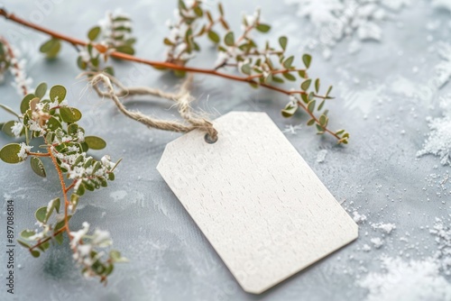 Empty white gift tag mockup. Paper label on snow covered background. Minimal winter still life photo