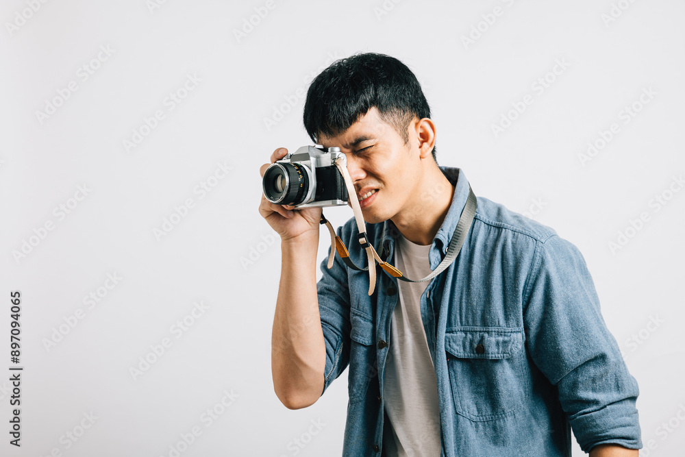 Young man's face lights up with joy as a photographer captures his charm with a vintage camera. Studio shot isolated on white background. This snapshot is sheer glamour Young man's face lights up with joy as a photographer captures his charm with a vintage camera. Studio shot isolated on white background. This snapshot is sheer glamour