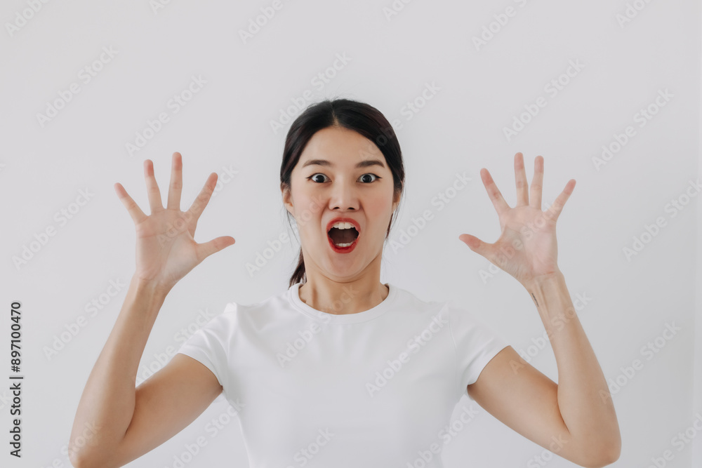 Funny shocked and wow face of asian Thai woman, open wide mouth, hand raising up and spreading out, big surprised of price and promotion, standing isolated over white background wall. Funny shocked and wow face of asian Thai woman, open wide mouth, hand raising up and spreading out, big surprised of price and promotion, standing isolated over white background wall.