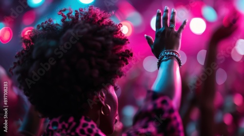 Wallpaper Mural A woman expresses joy and excitement, raising her hand in a crowd of people, with colorful lights creating an exhilarating atmosphere at a lively event or concert. Torontodigital.ca